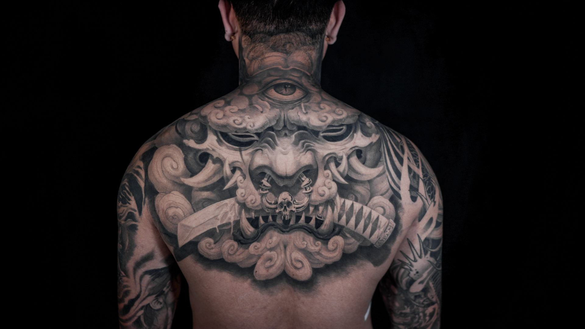 Black and grey oni mask back tattoo