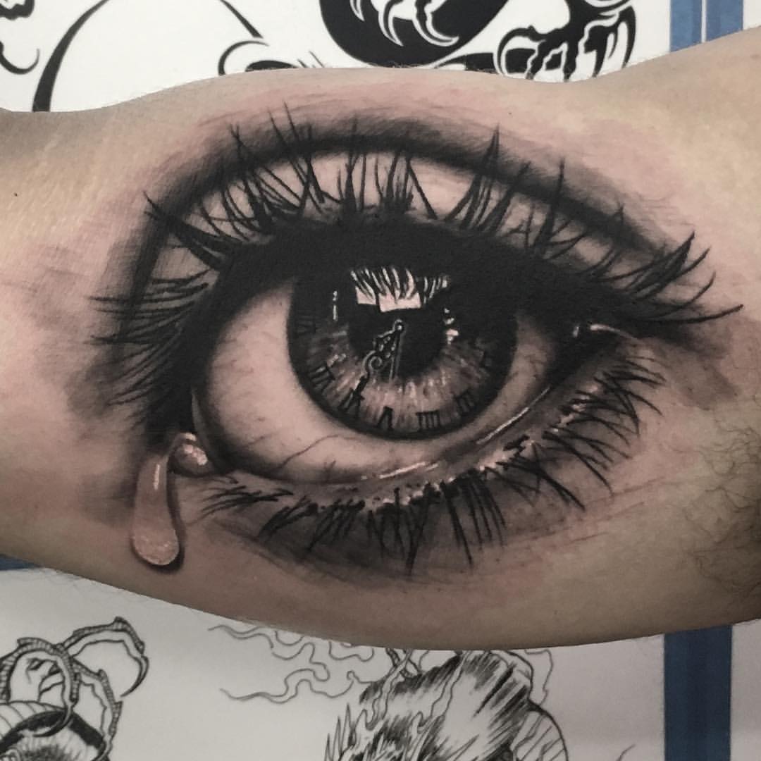 Realism clock eye tattoo on inner arm